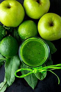 green apples and a pretty glass of green juice tied with a bow