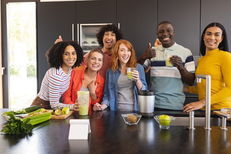 staff holding drinks and smiling behind the bar